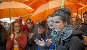 Jone Amezaga surrounded by supporters with orange (LIBRE's colour) umbrellas prior to police raid in Gernika